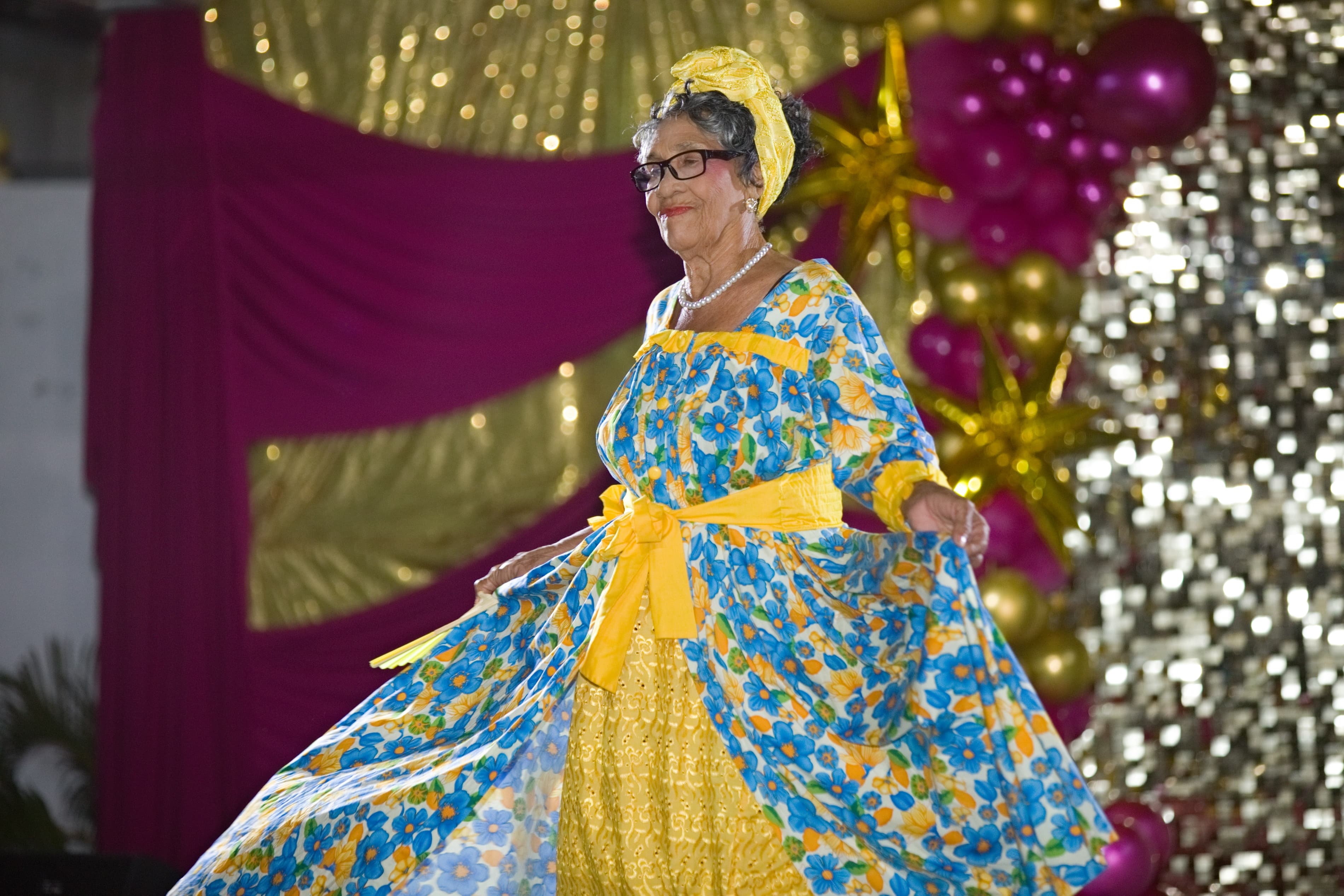 Une participante présente une tenue traditionnelle bleue et jaune.